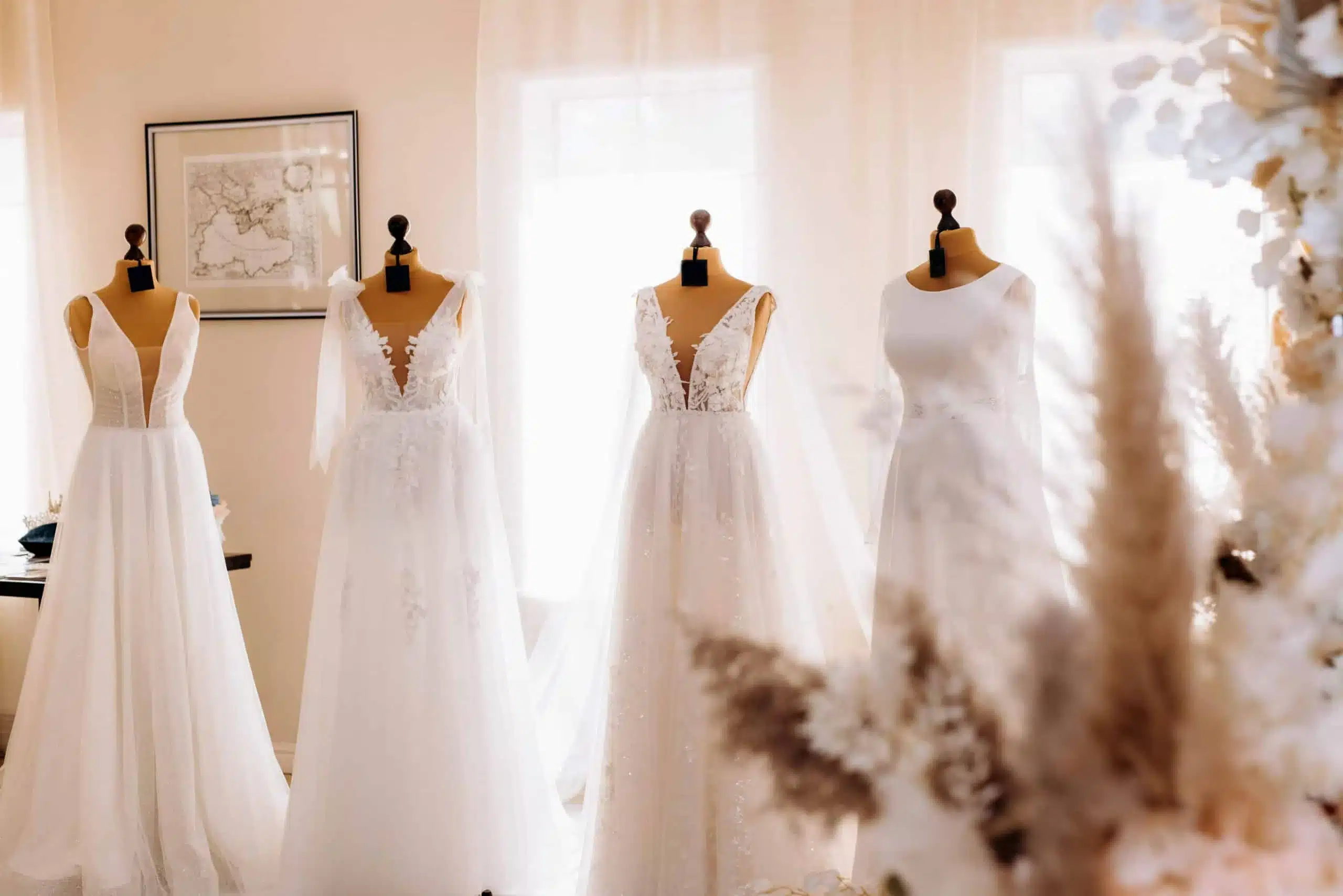Wedding dresses displayed on mannequins in a bright bridal boutique