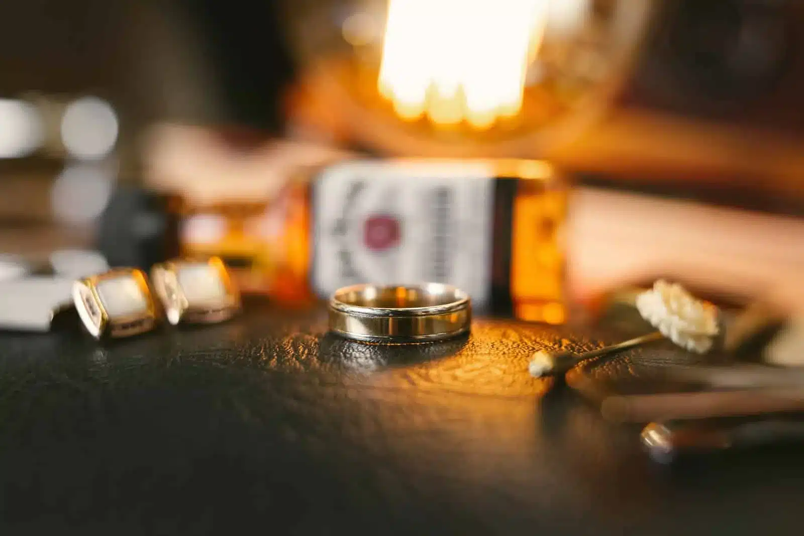 Wedding ring with groom accessories on a table.