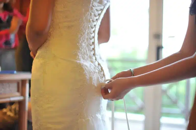 Bride having her wedding dress laced up
